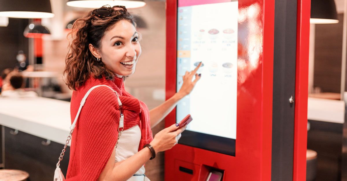 A girl orders food using a self-service kiosk.