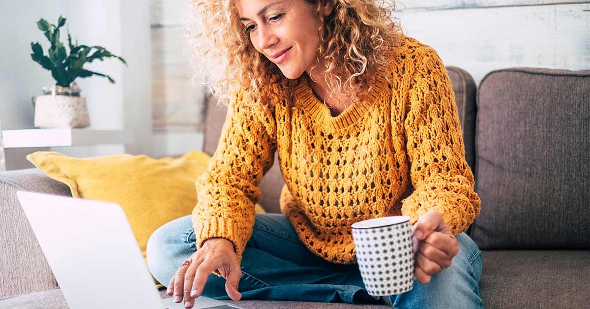 blonde curly hair working on a laptop